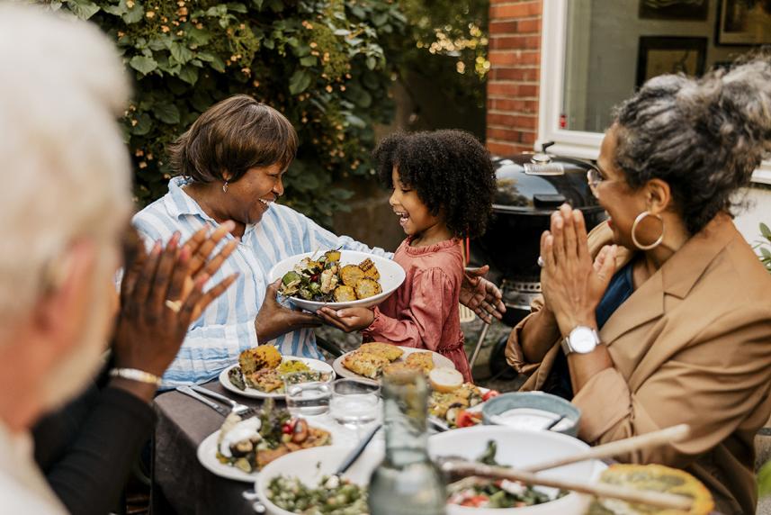 A family surrounding a table of plant based foods